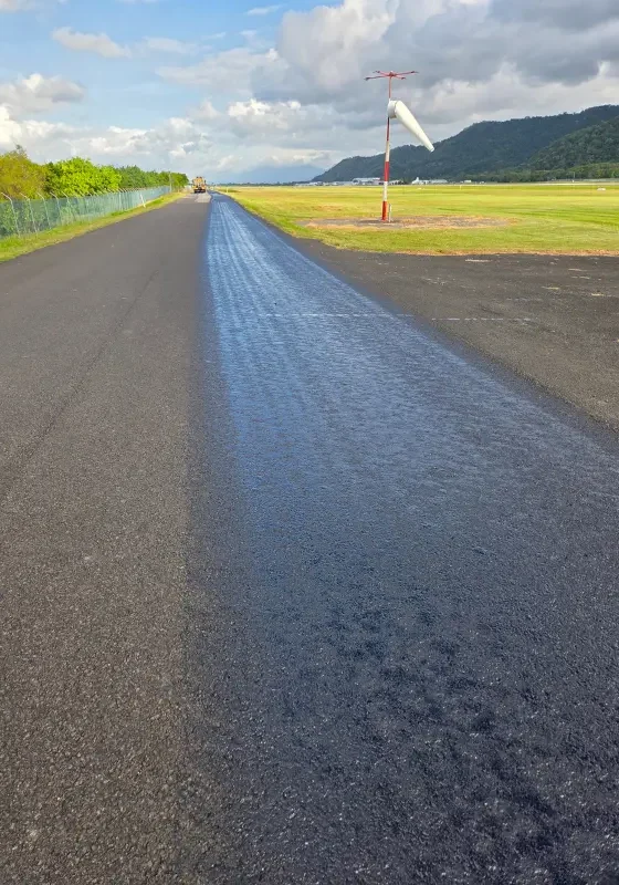 アスファルト舗装に保護材を散布する施工作業の様子